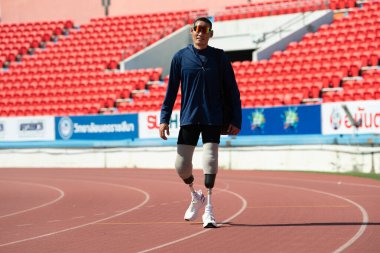 Stadyumdaki koşu pistinde protez bıçaklı Asyalı sporcular.