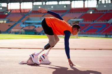 Stadyumdaki koşu pistinde protez bıçaklı Asyalı sporcular.