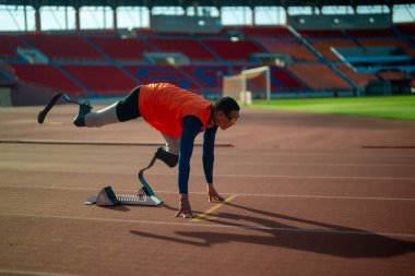 Stadyumdaki koşu pistinde protez bıçaklı Asyalı sporcular.