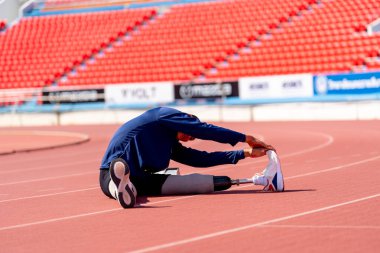 Stadyumdaki koşu pistinde protez bıçaklı Asyalı sporcular.