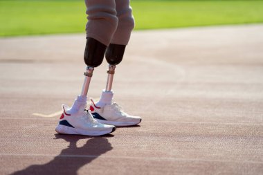 Stadyumdaki koşu pistinde protez bıçaklı Asyalı sporcular.