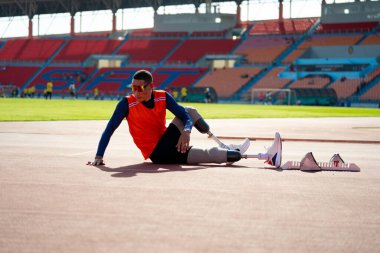 Stadyumdaki koşu pistinde protez bıçaklı Asyalı sporcular.