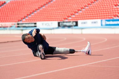 Stadyumdaki koşu pistinde protez bıçaklı Asyalı sporcular.