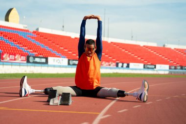 Stadyumdaki koşu pistinde protez bıçaklı Asyalı sporcular.