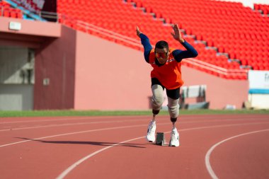 Stadyumdaki koşu pistinde protez bıçaklı Asyalı sporcular.