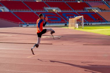 Stadyumdaki koşu pistinde protez bıçaklı Asyalı sporcular.