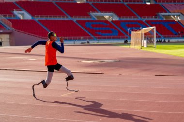Stadyumdaki koşu pistinde protez bıçaklı Asyalı sporcular.