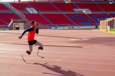 Stadyumdaki koşu pistinde protez bıçaklı Asyalı sporcular.