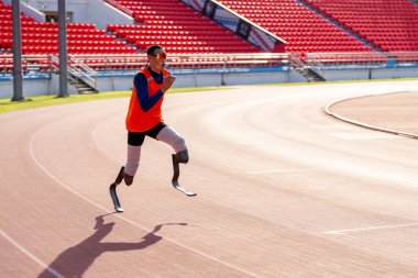 Stadyumdaki koşu pistinde protez bıçaklı Asyalı sporcular.