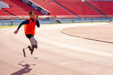 Stadyumdaki koşu pistinde protez bıçaklı Asyalı sporcular.