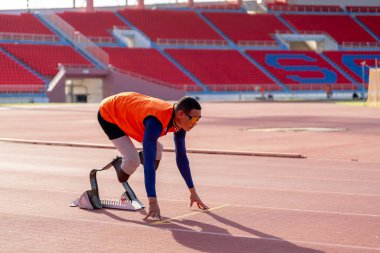 Stadyumdaki koşu pistinde protez bıçaklı Asyalı sporcular.
