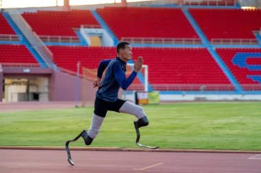 Stadyumdaki koşu pistinde protez bıçaklı Asyalı sporcular.