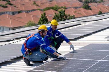 Profesyonel mühendisler güneş ışığı altında güneş çatılarını kontrol ediyorlar. Elektrik yenilenebilir eko enerji hizmeti veren mühendisler