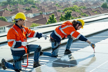 Profesyonel mühendisler güneş ışığı altında güneş çatılarını kontrol ediyorlar. Elektrik yenilenebilir eko enerji hizmeti veren mühendisler