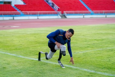 Stadyumdaki koşu pistinde protez bıçaklı Asyalı sporcular.