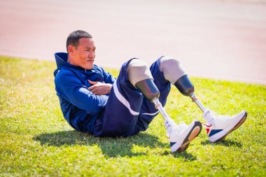 Stadyumdaki koşu pistinde protez bıçaklı Asyalı sporcular.