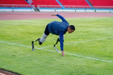 Stadyumdaki koşu pistinde protez bıçaklı Asyalı sporcular.