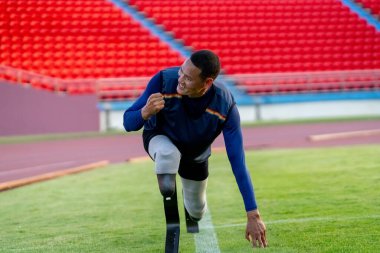 Stadyumdaki koşu pistinde protez bıçaklı Asyalı sporcular.