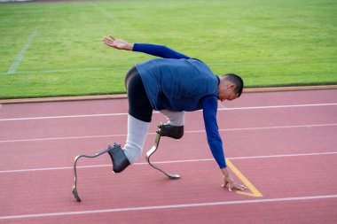 Stadyumdaki koşu pistinde protez bıçaklı Asyalı sporcular.