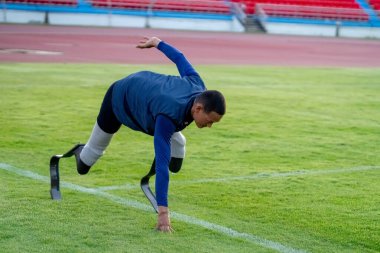 Stadyumdaki koşu pistinde protez bıçaklı Asyalı sporcular.