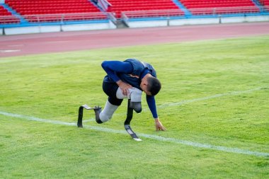 Stadyumdaki koşu pistinde protez bıçaklı Asyalı sporcular.