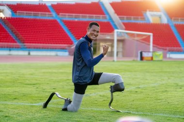 Stadyumdaki koşu pistinde protez bıçaklı Asyalı sporcular.