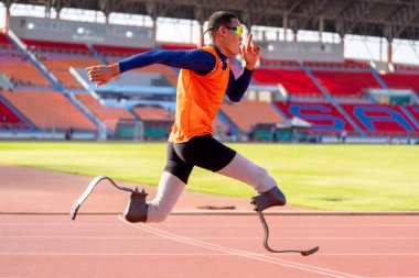 Stadyumdaki koşu pistinde protez bıçaklı Asyalı sporcular.
