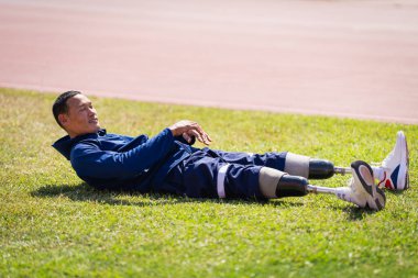 Stadyumdaki koşu pistinde protez bıçaklı Asyalı sporcular.