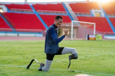 Stadyumdaki koşu pistinde protez bıçaklı Asyalı sporcular.