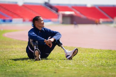 Stadyumdaki koşu pistinde protez bıçaklı Asyalı sporcular.