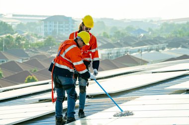 Profesyonel mühendisler güneş ışığı altında güneş çatılarını kontrol ediyorlar. Elektrik yenilenebilir eko enerji hizmeti veren mühendisler