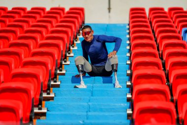 Stadyumdaki koşu pistinde protez bıçaklı Asyalı sporcular.