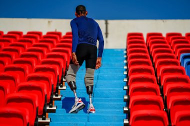 Stadyumdaki koşu pistinde protez bıçaklı Asyalı sporcular.