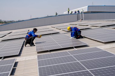 Profesyonel mühendisler güneş ışığı altında güneş çatılarını kontrol ediyorlar. Elektrik yenilenebilir enerji hizmeti veren mühendisler