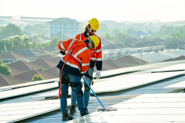 Profesyonel mühendisler güneş ışığı altında güneş çatılarını kontrol ediyorlar. Elektrik yenilenebilir eko enerji hizmeti veren mühendisler