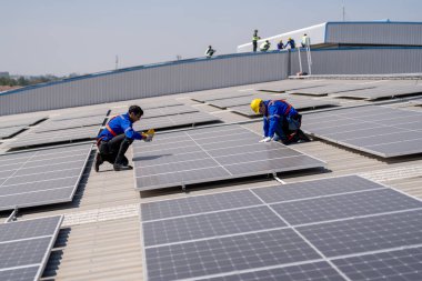 Profesyonel mühendisler güneş ışığı altında güneş çatılarını kontrol ediyorlar. Elektrik yenilenebilir enerji hizmeti veren mühendisler