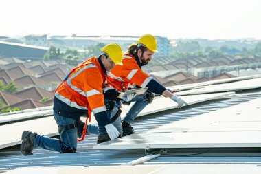 Profesyonel mühendisler güneş ışığı altında güneş çatılarını kontrol ediyorlar. Elektrik yenilenebilir eko enerji hizmeti veren mühendisler