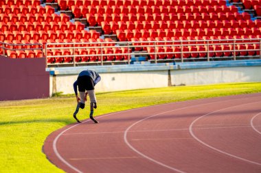 Stadyumdaki koşu pistinde protez bıçaklı Asyalı sporcular.