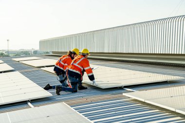 Profesyonel mühendisler güneş ışığı altında güneş çatılarını kontrol ediyorlar. Elektrik yenilenebilir eko enerji hizmeti veren mühendisler