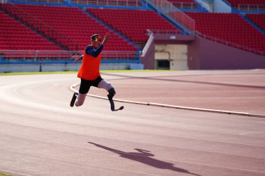 Stadyumdaki koşu pistinde protez bıçaklı Asyalı sporcular.