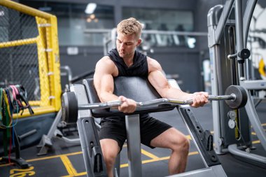 Spor salonundaki yakışıklı, formda adam halter kaldırıyor.