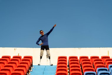 Stadyumdaki koşu pistinde protez bıçaklı Asyalı sporcular.