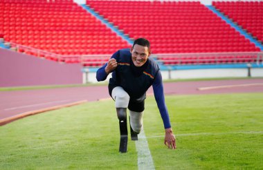 Stadyumdaki koşu pistinde protez bıçaklı Asyalı sporcular.