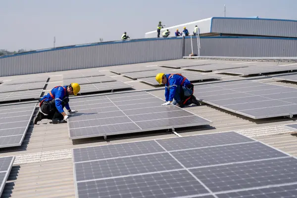 Profesyonel mühendisler güneş ışığı altında güneş çatılarını kontrol ediyorlar. Elektrik yenilenebilir enerji hizmeti veren mühendisler