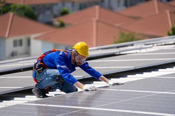 Professional engineer checking solar roof panel on the factory rooftop under sunlight. Engineer having service job of electrical renewable eco energy