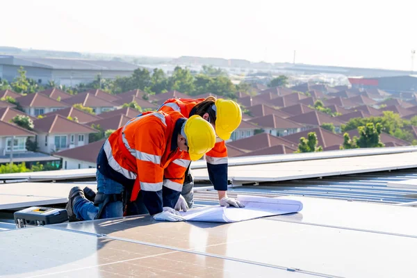 Profesyonel mühendisler güneş ışığı altında güneş çatılarını kontrol ediyorlar. Elektrik yenilenebilir eko enerji hizmeti veren mühendisler