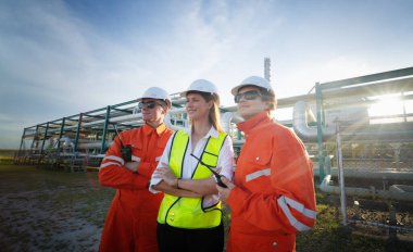 Fabrika mühendisi veya teknisyen işçiler arıtma ve petrokimya fabrikasının önünde duruyorlar.