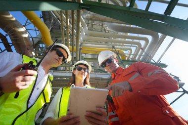 Fabrika mühendisi veya teknisyen işçiler arıtma ve petrokimya fabrikasının önünde duruyorlar.