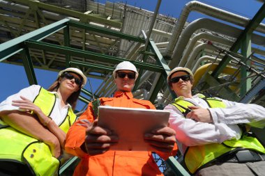 Fabrika mühendisi veya teknisyen işçiler arıtma ve petrokimya fabrikasının önünde duruyorlar.