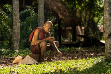 Ahşap bir kütüğün üzerinde oturan keşiş